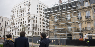 Deux personnes observant un immeuble en rénovation